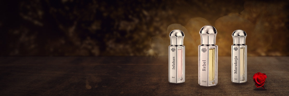 Isfahan, Rebel and Marakoja Attar by MHB Essence on dark wood with a red rose